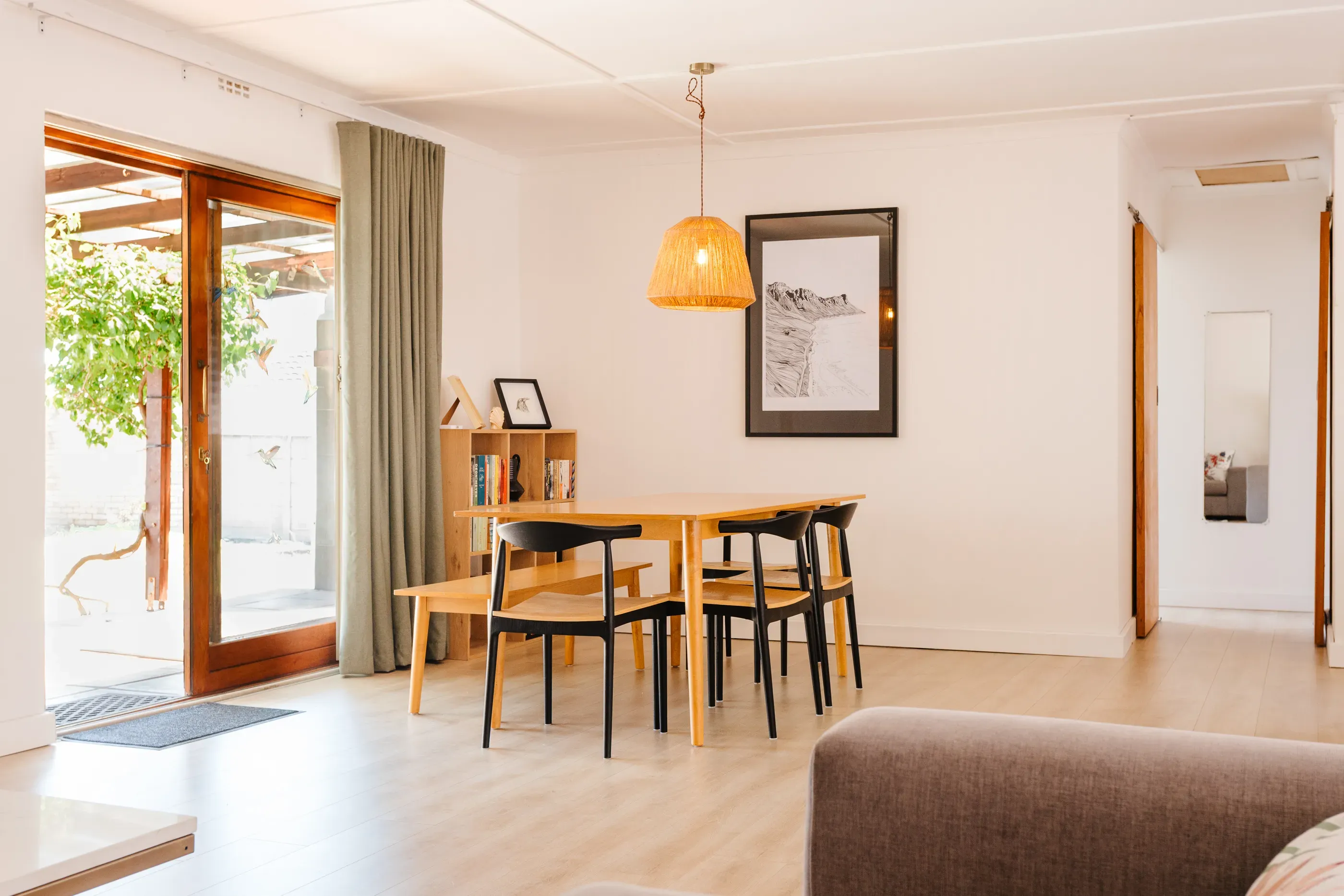 The bright, open-plan dining and living area at Kommetjie Flow, showing a modern interior designed for comfort and connection in Cape Town.